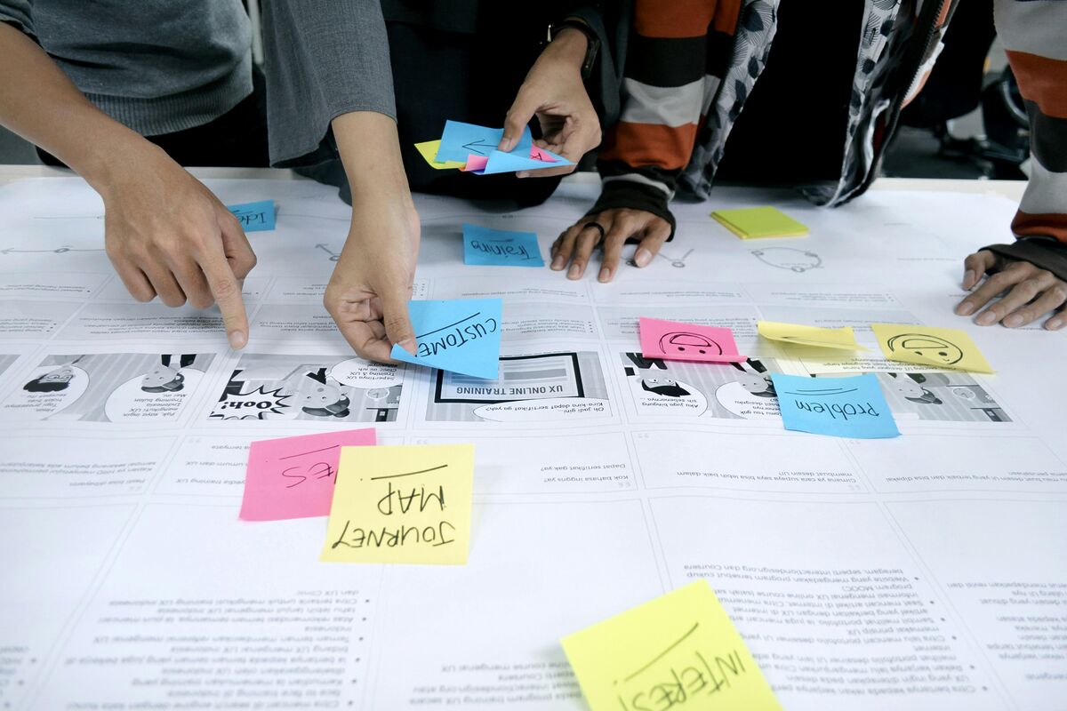 Equipe revisando criação de identidade profissional completa para marca corporativa com moodboard e amostras de cores