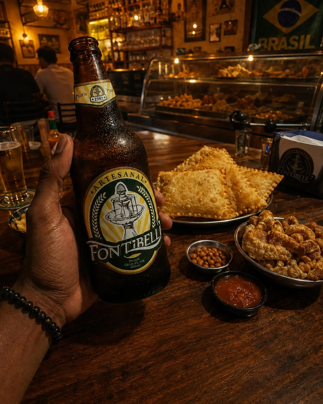 Garrafa de cerveja Fontibelli com rótulo em destaque e aplicações da identidade visual.